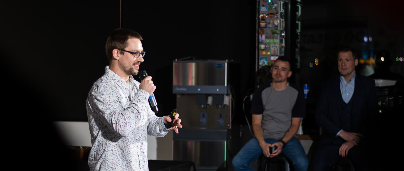 A Jahnel Group engineer presenting at an internal TED-style talk while teammates listen