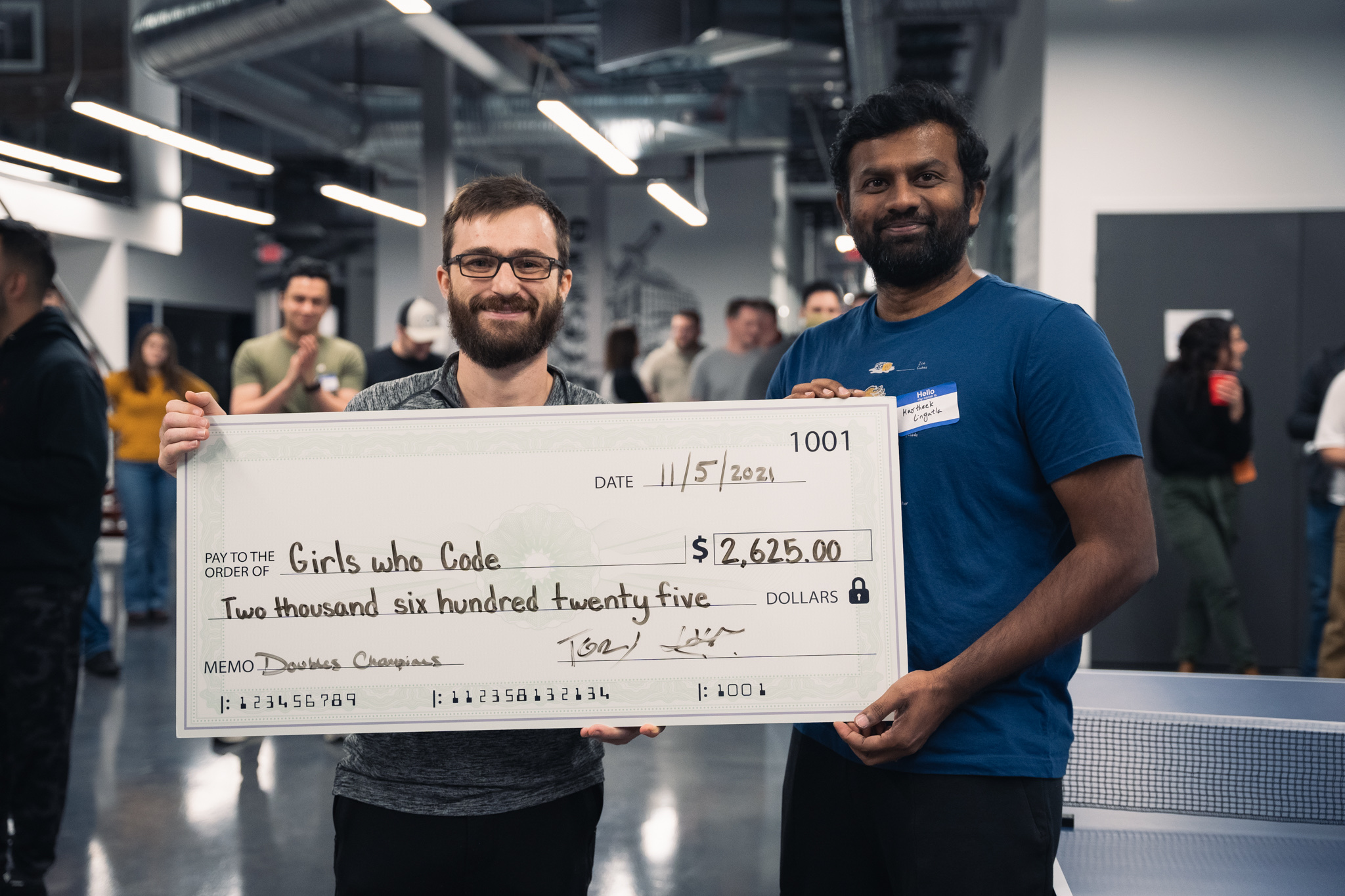 Doubles champions hold a charity check made out to Girls Who Code